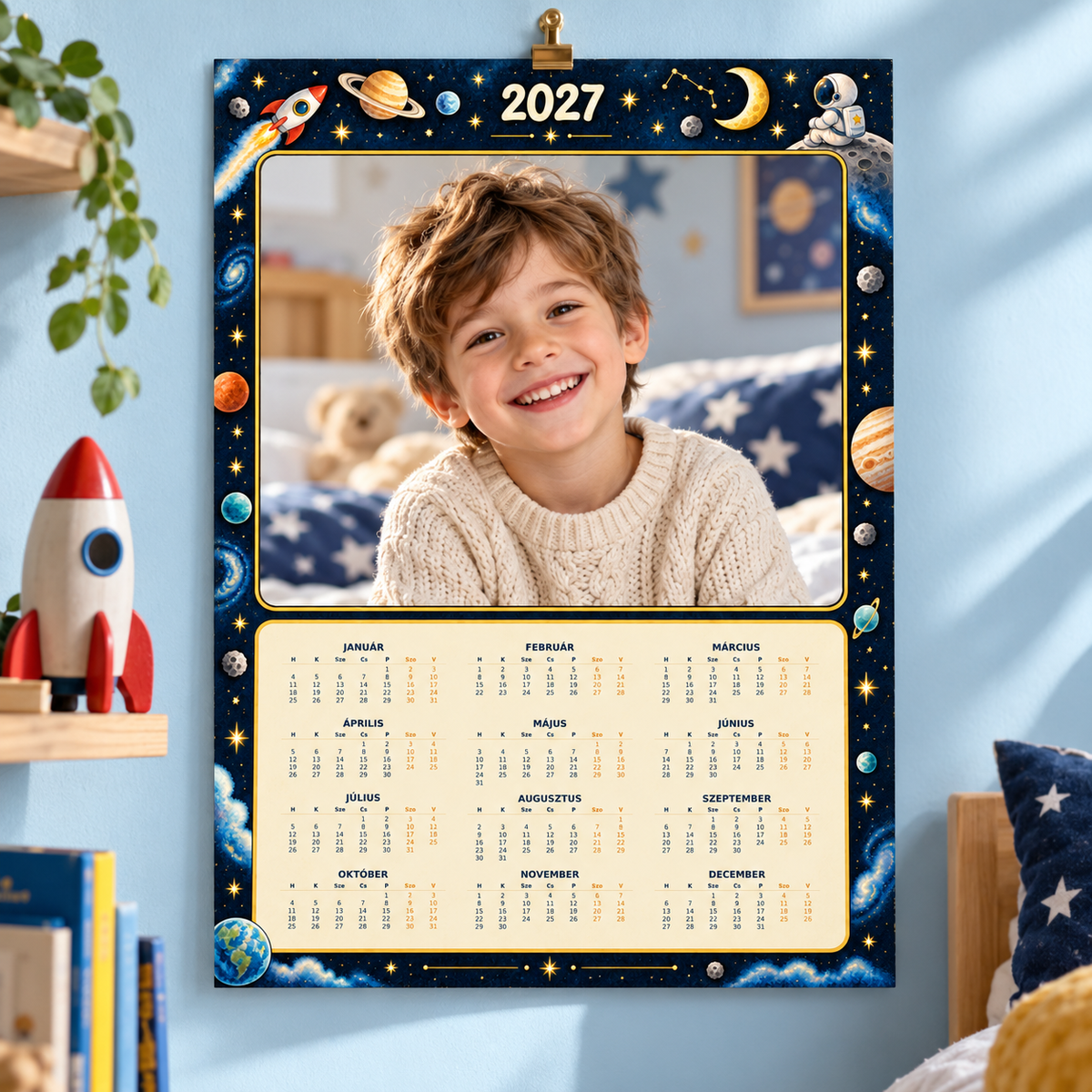 GG Pix – Calendar foto 2027 Aventură spațială pe o singură pagină, prezentat pe perete cu fotografie demonstrativă.